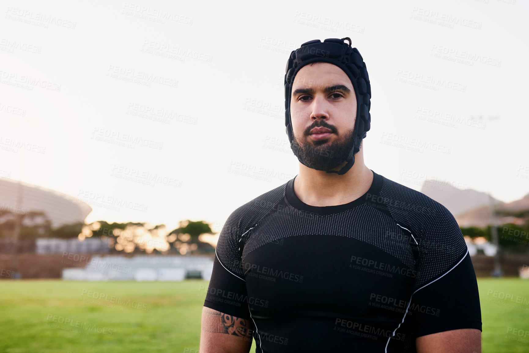 Buy stock photo Cropped portrait of a handsome young sportsman wearing headgear and standing alone during rugby practice during the day