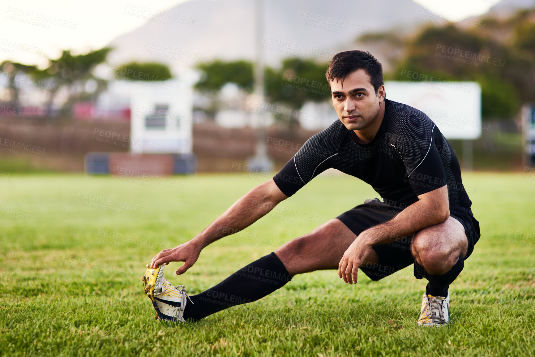 Buy stock photo Sport, rugby and player stretching for fitness on grass field with match warm up, game workout and performance. Athlete, man and leg exercise for competition preparation and practice for tournament