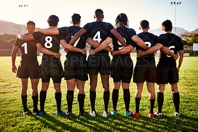 Buy stock photo Full length shot of a unrecognizable group of sportsmen standing together with their arms around each other before playing rugby
