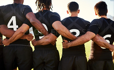 Buy stock photo Cropped shot of a unrecognizable group of sportsmen standing together with their arms around each other before playing rugby