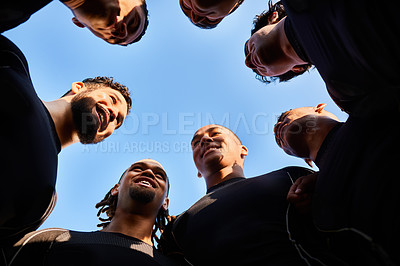 Buy stock photo Low angle shot of a diverse group of sportsmen huddled together before playing a game of rugby