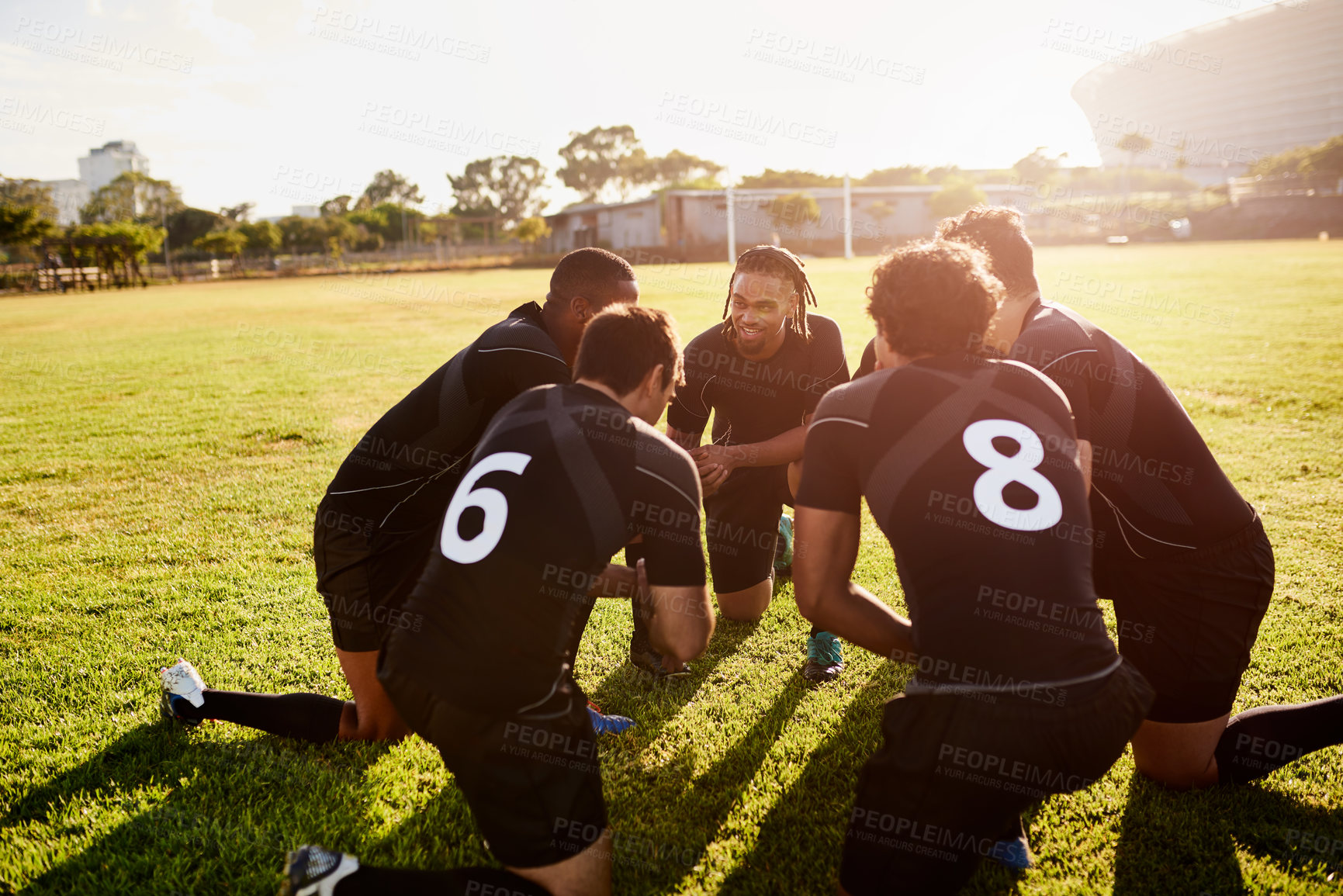 Buy stock photo Cropped shot of a diverse group of sportsmen crouching together before playing rugby during the day