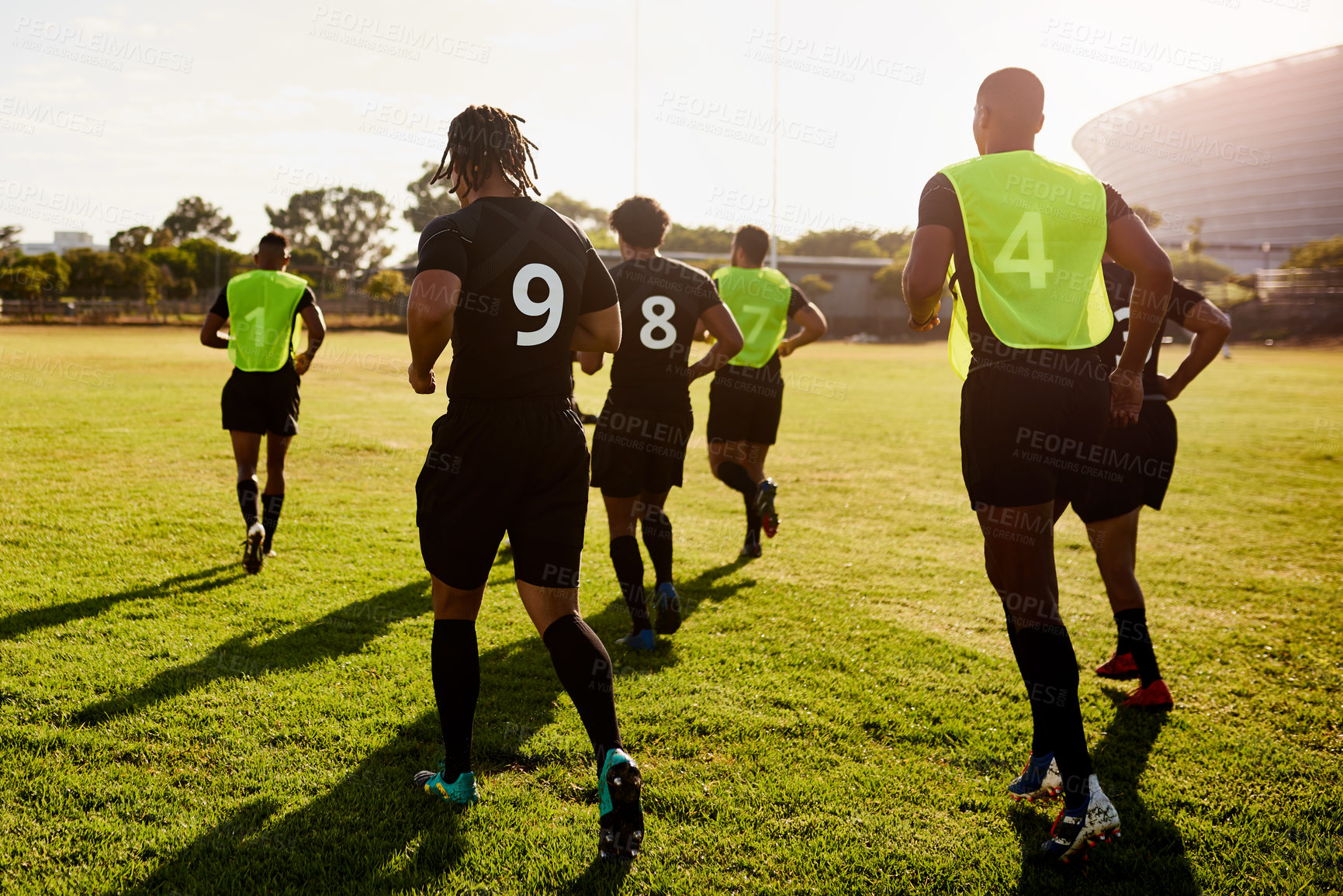 Buy stock photo Sports, back and men with training for rugby, competition game or practice with warm up for match. Stadium, group and players with running for fitness, stretching or club team for tournament by flare