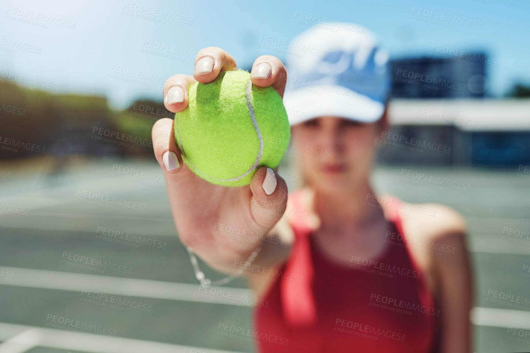 Buy stock photo Cropped shot of an unrecognizable sportswoman standing alone and holding a tennis ball during a training session