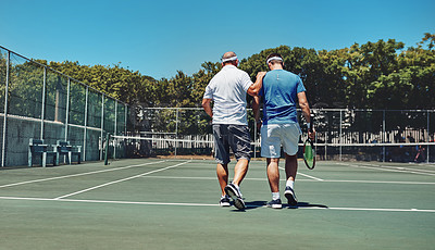 Buy stock photo Full length shot of two unrecognizable sportsmen walking together on a tennis court after a training session