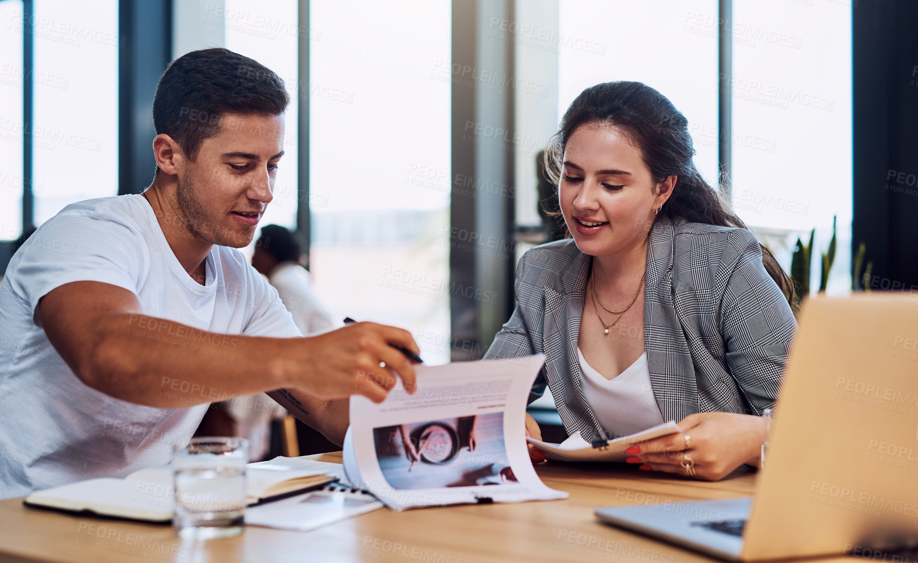 Buy stock photo Shot of two businesspeople going through paperwork together in an office