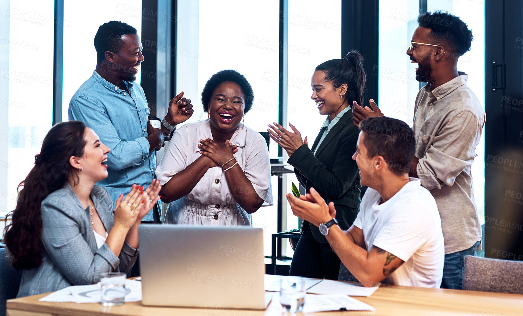 Buy stock photo Shot of a group of businesspeople applauding a colleague in an office