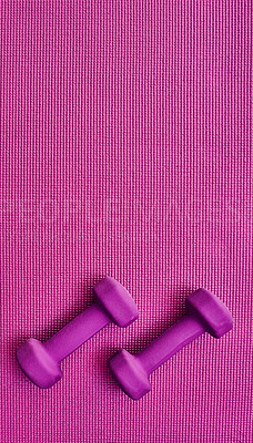 Buy stock photo High angle shot of two lightweight dumbbells placed on a pink background inside of a studio