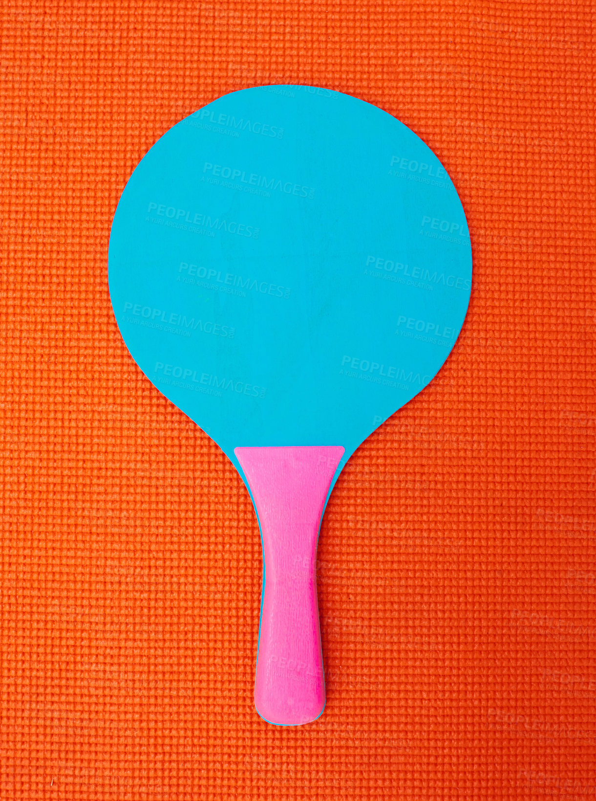 Buy stock photo High angle shot of a table tennis bat placed on top of an orange background inside of a studio