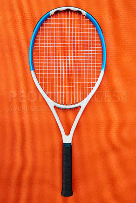 Buy stock photo High angle shot of a single tennis racket placed on an orange background inside of a studio