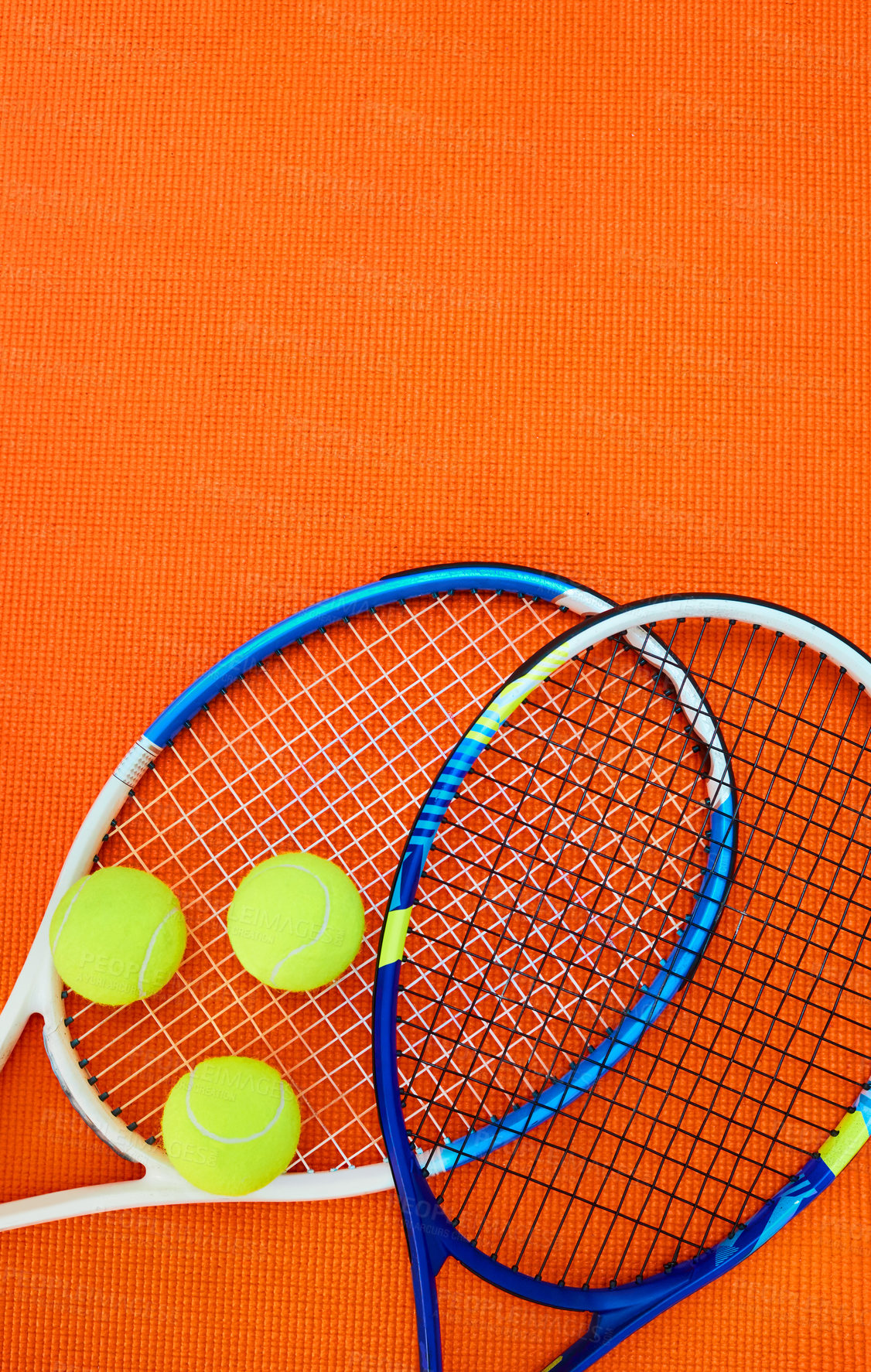 Buy stock photo High angle shot of tennis essentials placed on top of an orange background inside of a studio