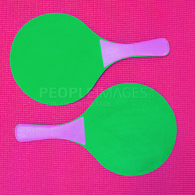 Buy stock photo High angle shot of two green table tennis rackets placed on top of a pink background inside of a studio