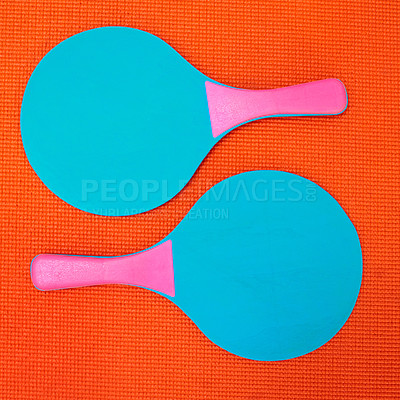 Buy stock photo Above of bats in studio for fitness, fun or retro aesthetic on orange background. Sport paddles on textured backdrop in table tennis game, strategy or skill development