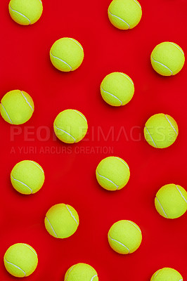 Buy stock photo High angle shot of a group of tennis balls placed together in formation on top of a red background inside of a studio
