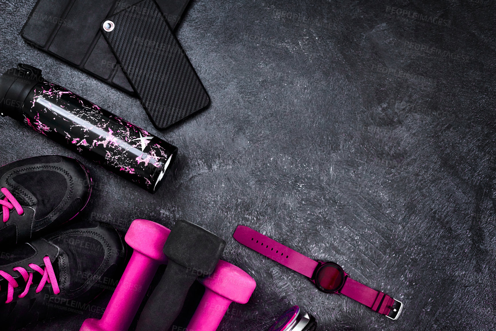 Buy stock photo High angle shot of a group of workout essentials lying on top of a dark background  inside of a studio