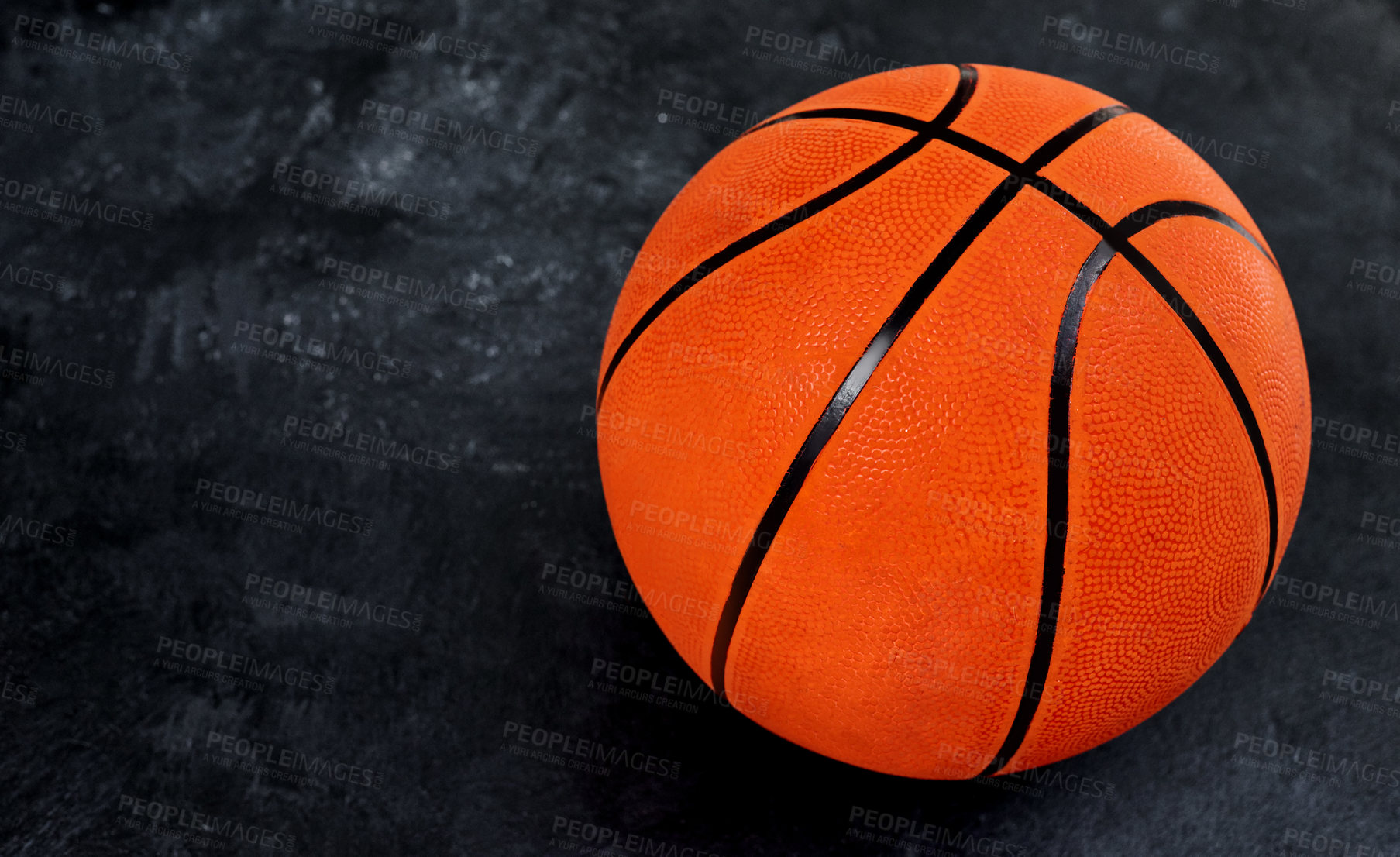 Buy stock photo High angle shot of a single basket ball placed on top of a dark background inside of a studio