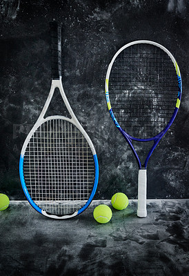 Buy stock photo Studio shot of tennis essentials placed against a dark background inside of a studio
