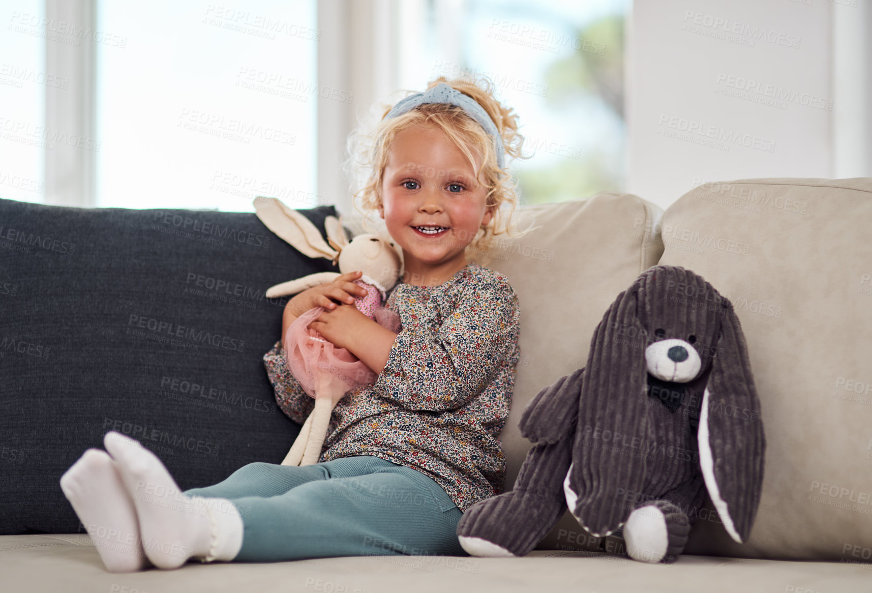 Buy stock photo Full length portrait of an adorable little girl sitting alone on the sofa and playing with her toys at home