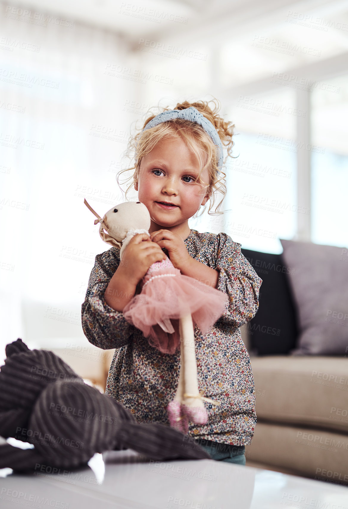 Buy stock photo Cropped shot of an adorable little girl standing alone in the living room and playing with her toys at home