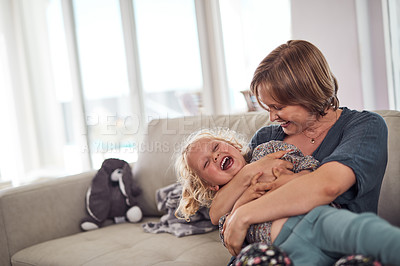 Buy stock photo Cropped shot of an attractive young mother sitting on the sofa and hugging her daughter at home