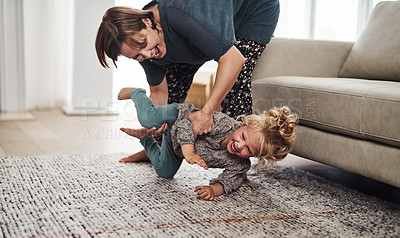 Buy stock photo Cropped shot of an attractive young mother and playing with her daughter in the living room at home