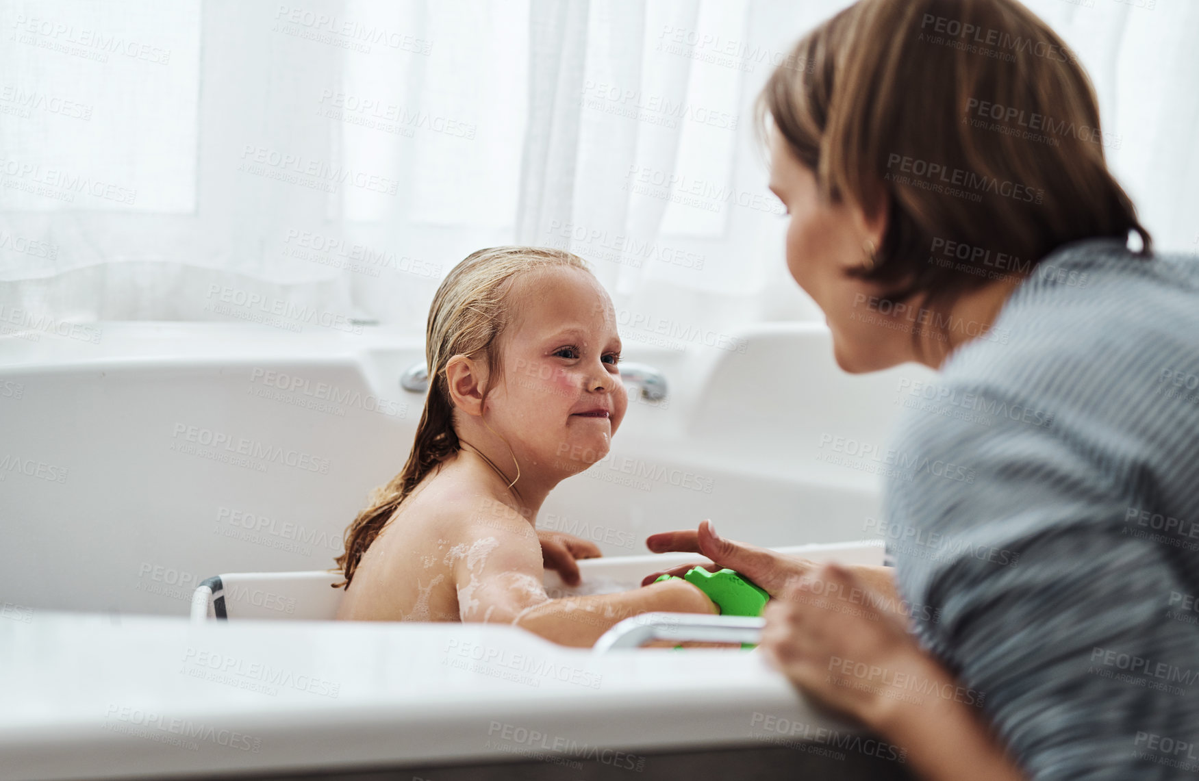 Buy stock photo Cropped shot of an adorable little girl bonding with her mother while taking a bath at home