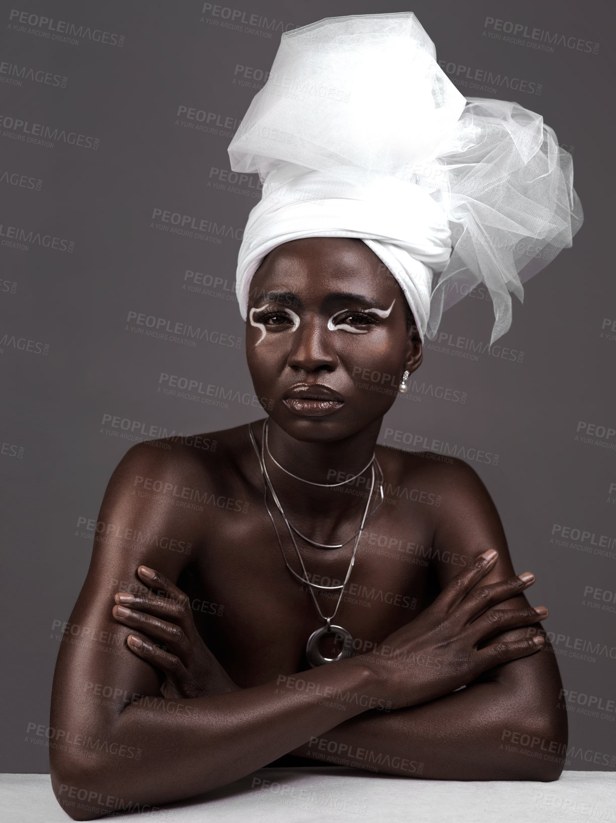 Buy stock photo Studio portrait of an attractive young woman posing in traditional African attire against a grey background
