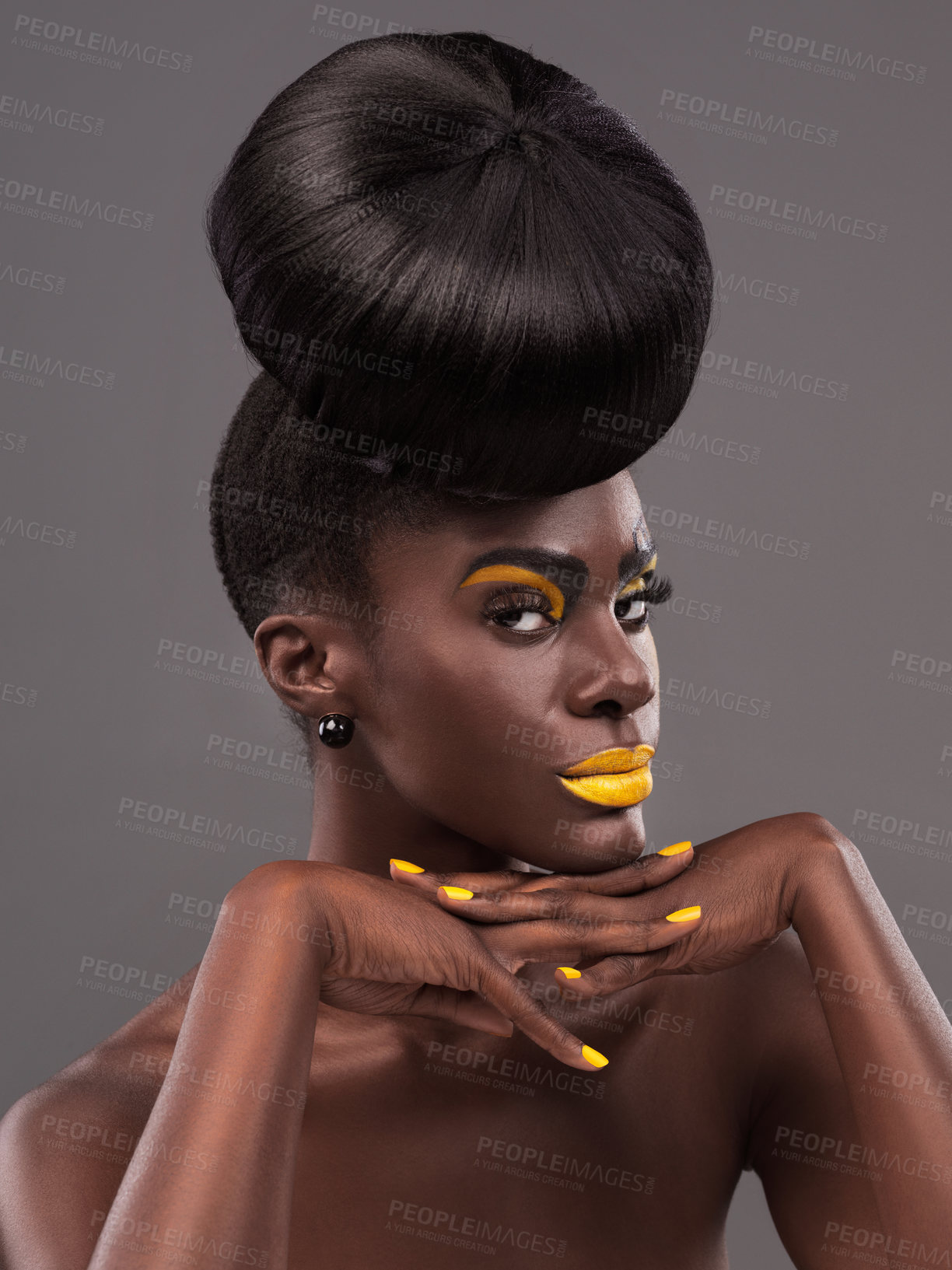 Buy stock photo African, model and edgy portrait with makeup, beauty and creative yellow lipstick. Bold, woman and skin with confidence, dramatic hair and bun for glamour and trendy cosmetics on grey background