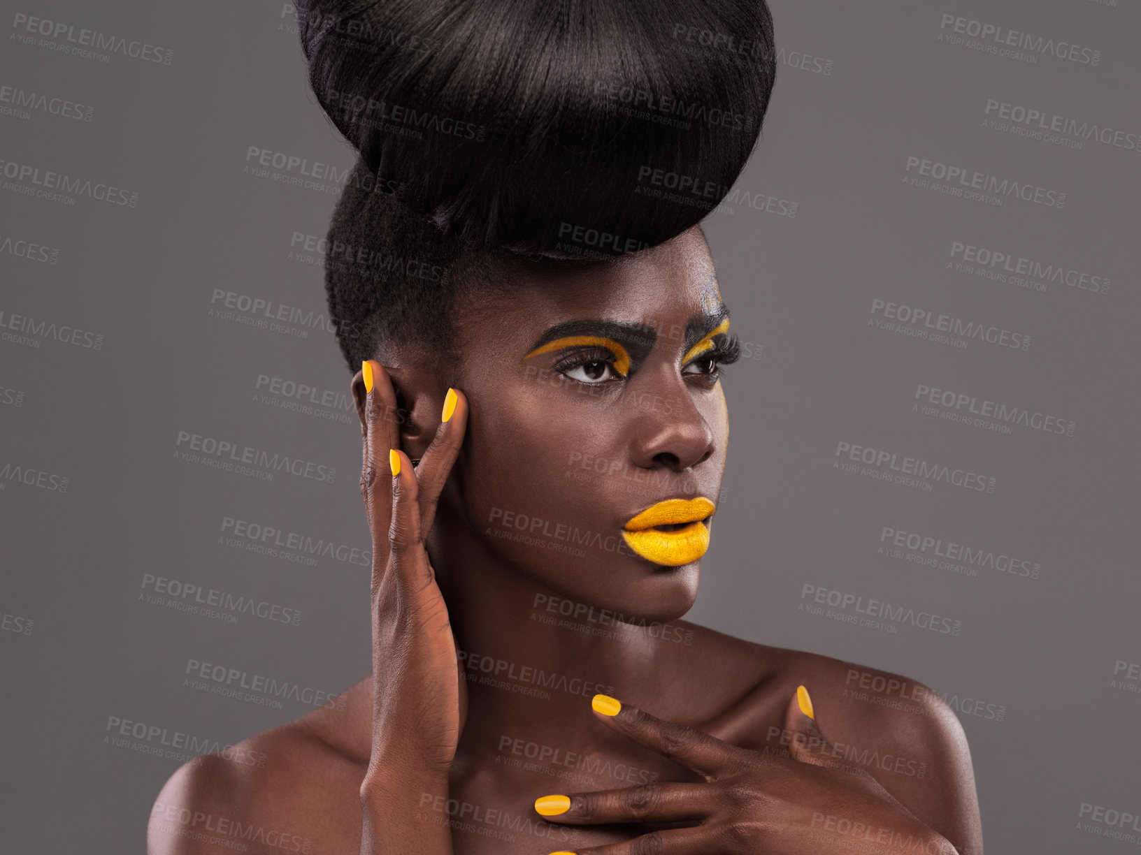 Buy stock photo African, model and studio artistic with makeup, beauty and creative yellow lipstick. Bold, woman and skin with confidence, dramatic hair and bun for glamour and trendy cosmetics on grey background
