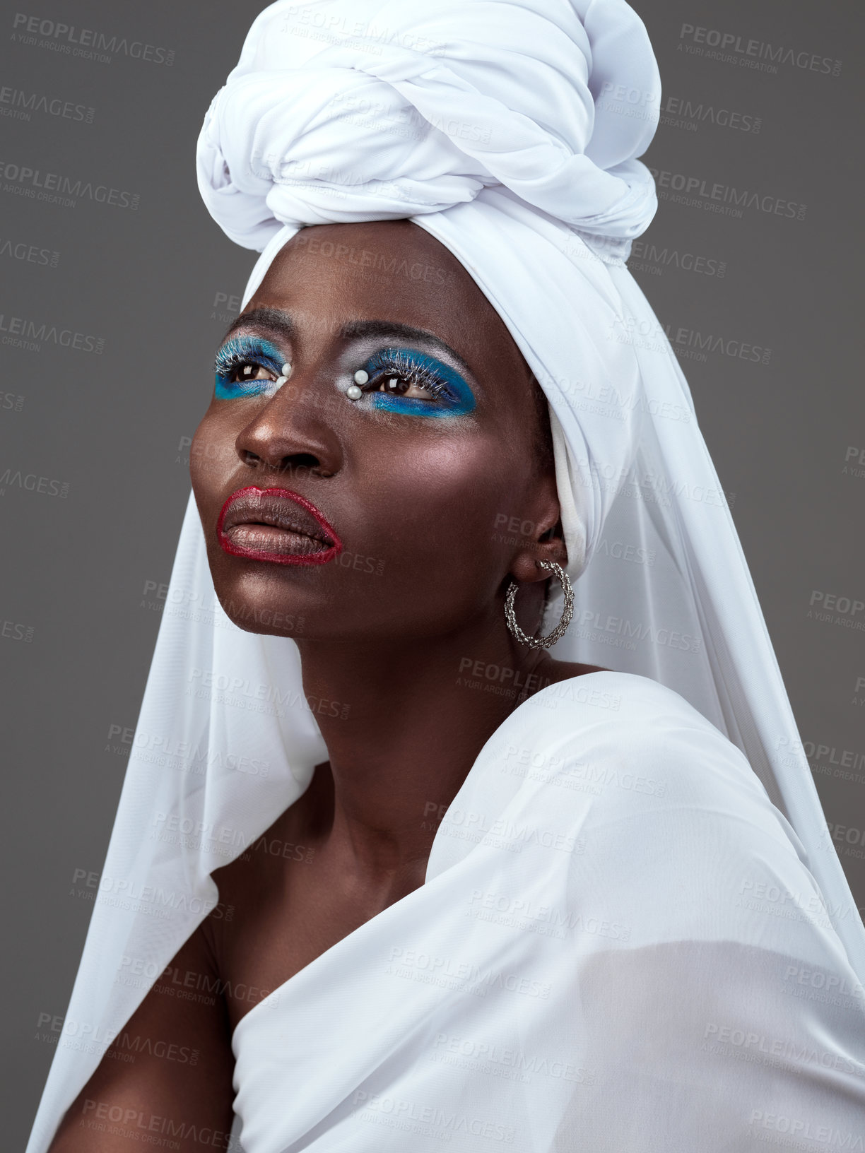 Buy stock photo African, woman and cosmetics or fashion in makeup with traditional clothing, head scarf and studio backdrop. Female person, stylish and confident for heritage, pride and culture in grey background