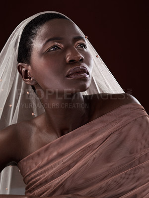 Buy stock photo Studio shot of an attractive young woman posing in traditional African attire against a black background