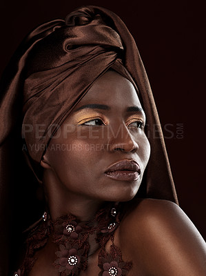 Buy stock photo Studio shot of an attractive young woman posing in traditional African attire against a black background