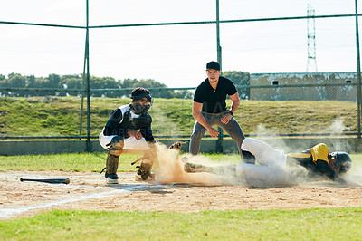 Buy stock photo Full length shot of a young baseball player reaching base during a match on the field