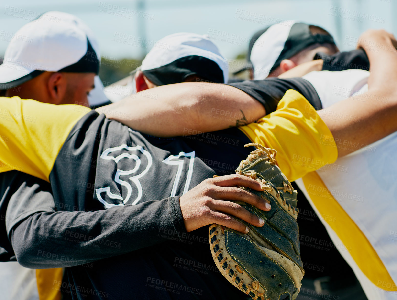 Buy stock photo Cropped shot of a team of unrecognizable baseball players standing together in a huddle on the field