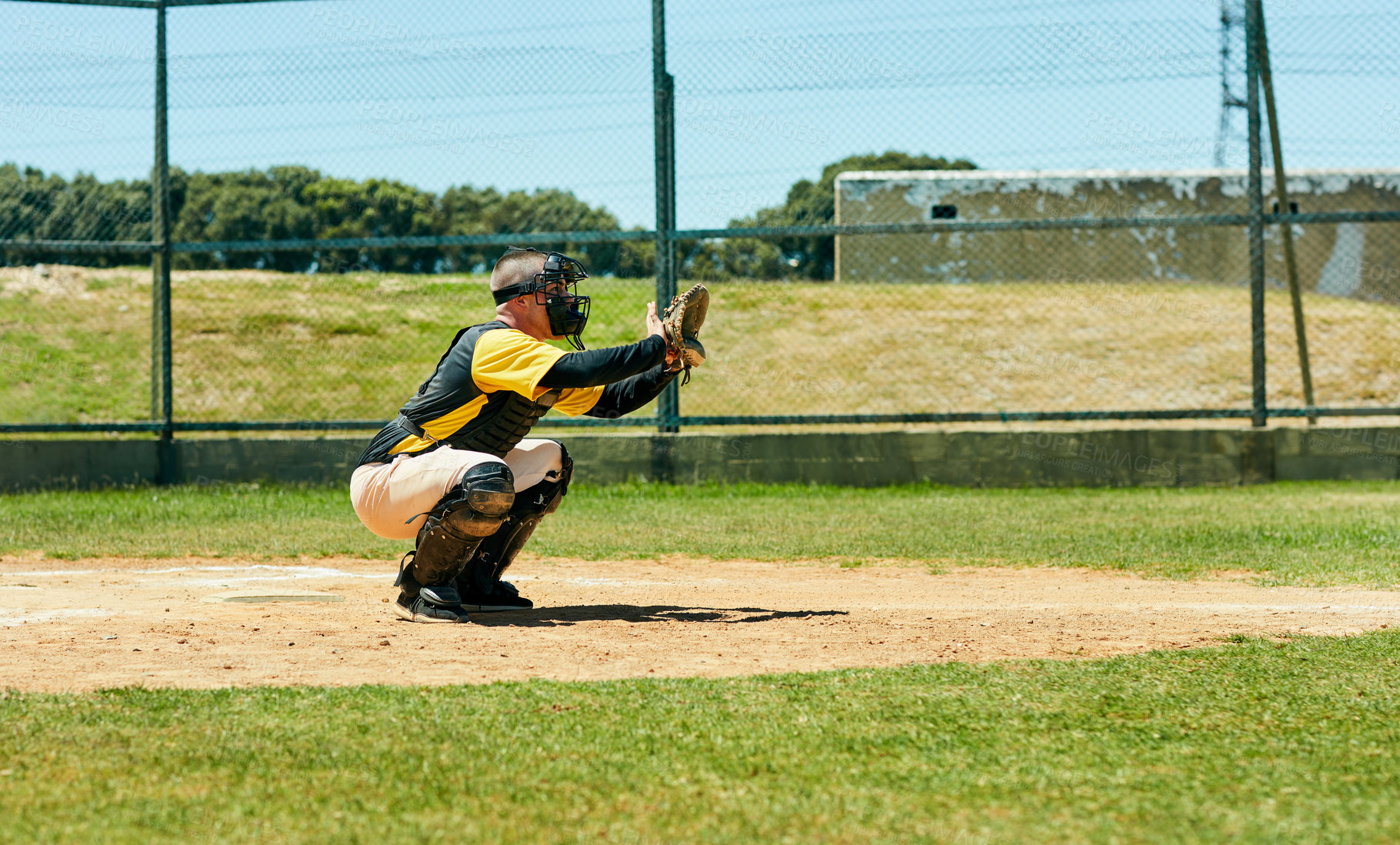 Buy stock photo Full length shot of a young baseball player preparing to catch a ball during a match on the field