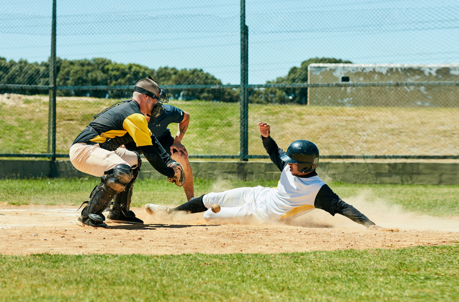 Buy stock photo Full length shot of a young baseball player reaching base during a match on the field