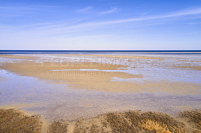 Buy stock photo A landscape of the beach shore and blue sky background with copy space on a summer day. The sea or ocean during low tide with copyspace. Peaceful and scenic view of endless sandy water