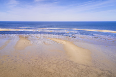 Buy stock photo Landscape of a beach shore and blue sky over the horizon in the background with copy space on a summer day. A peaceful and scenic view of endless sandy water of the sea or ocean during low tide