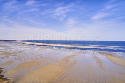Buy stock photo Copyspace at the beach with a blue sky background above the horizon. Calm ocean waves across an empty sea along the sandy shore. Tranquil landscape for a relaxing and zen summer holiday in Denmark