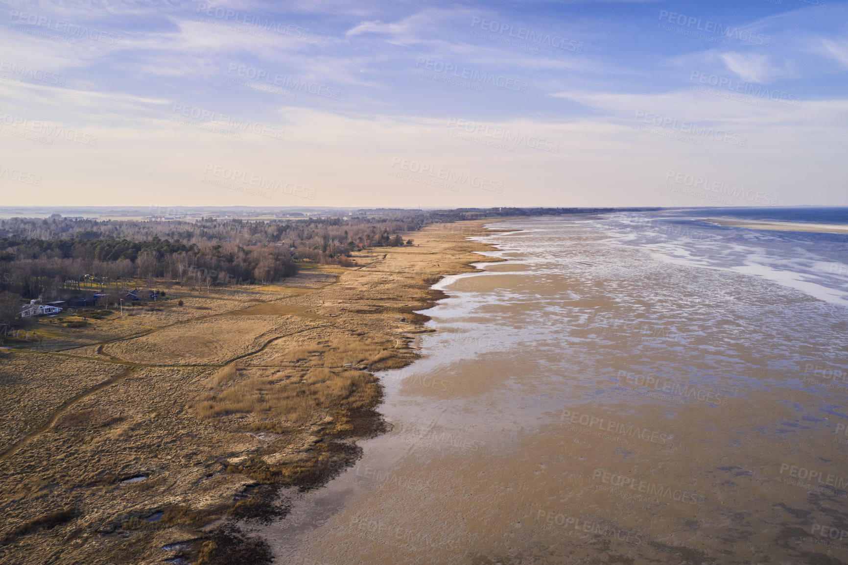 Buy stock photo Beautiful landscape of forest dry land near the beach with copy space. Aerial view of the coastline on a summer day with a cloudy blue sky background and copyspace. A peaceful view of the coast