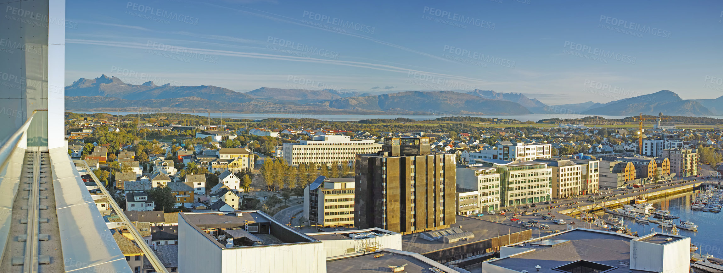 Buy stock photo Cityscape view of urban city buildings and infrastructure with background mountains in popular overseas travel destination. Busy downtown centre and urban architecture and blue sky in Bodo, Norway