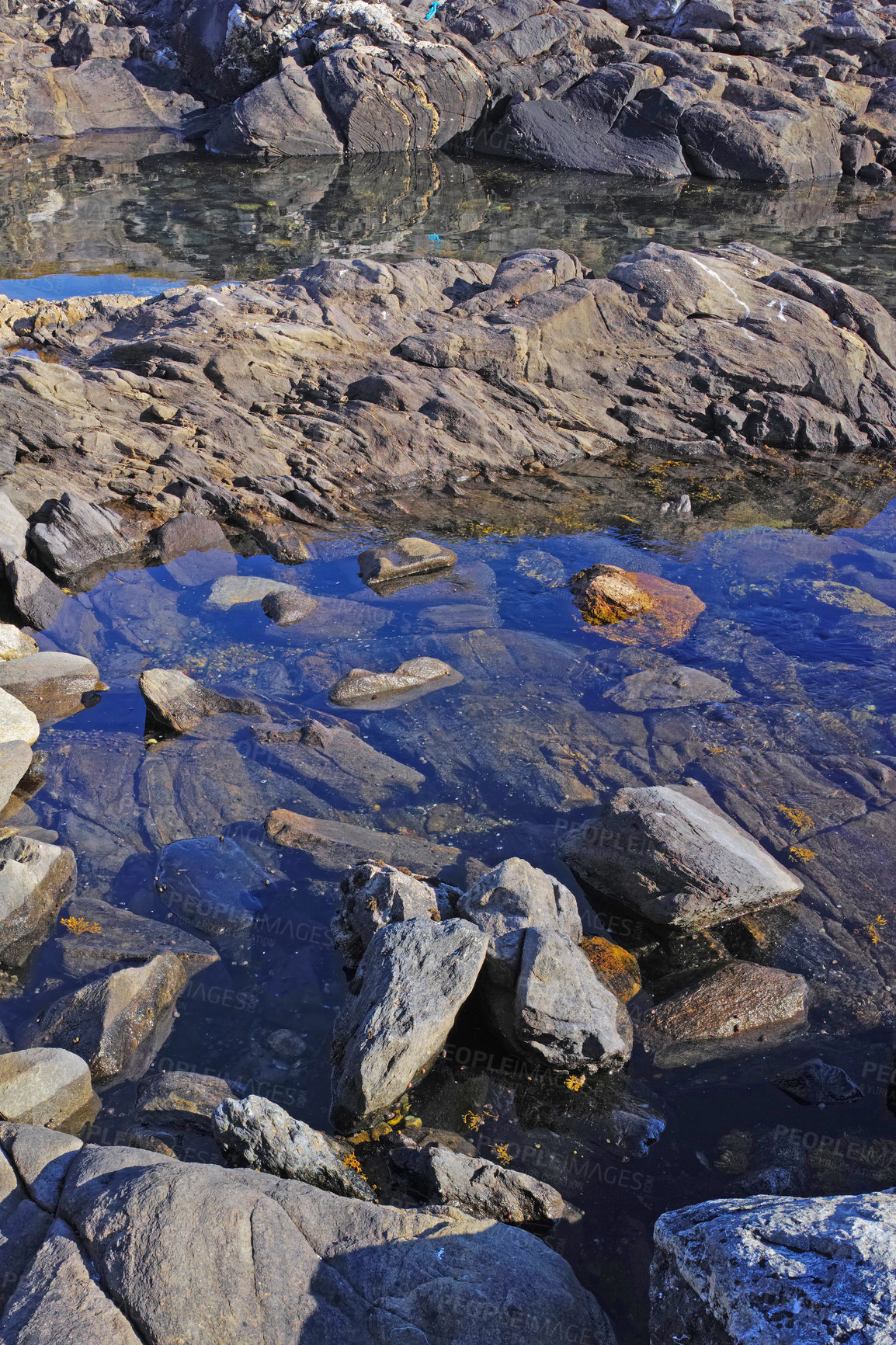 Buy stock photo Ocean tide forming natural rock dipping pools for swimming and relaxing. Fresh and clear water collecting in natural reservoirs. Scenic view of stones in a calm, serene and tranquil nature landscape
