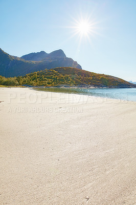 Buy stock photo Public beach close to the city of Bodoe, North of the Polar Circle, Norway. Empty sand basked in bright sunlight with a lush green mountain in the background. Deserted beach in its natural beauty