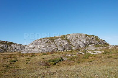 Buy stock photo Scenic landscape of Bodo in Nordland with natural surrounding and blue sky copyspace background. Rock formation on mountain and hill with dry barren plants. Hiking trails in the countryside of Norway