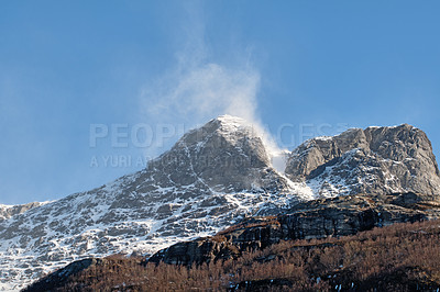 Buy stock photo Beautiful landscape of a snowy mountain top with a blue sky and copy space. A streaming peak with frost on a winter afternoon. Peaceful and scenic outdoors with a summit in nature