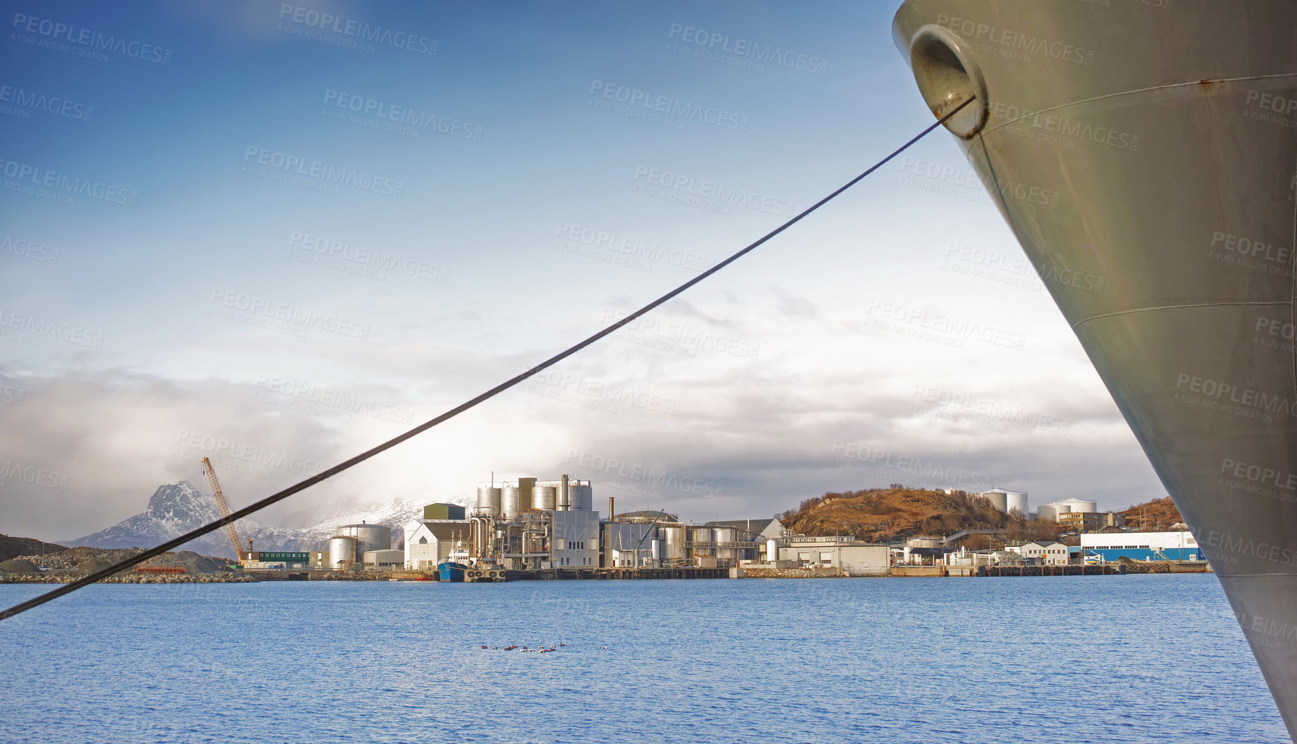 Buy stock photo Factory, ocean and boat with cable to dock, international distribution and shipping industry at harbor. Sea port, production plant and cargo vessel with line to anchor, marine transport and Norway