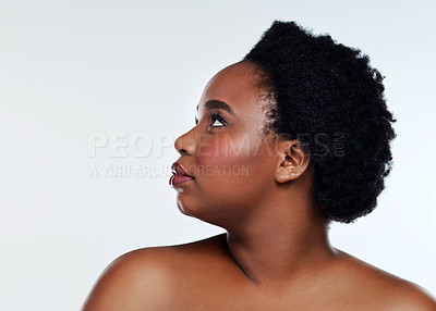 Buy stock photo Studio shot of a beautiful young woman looking thoughtful against a gray background
