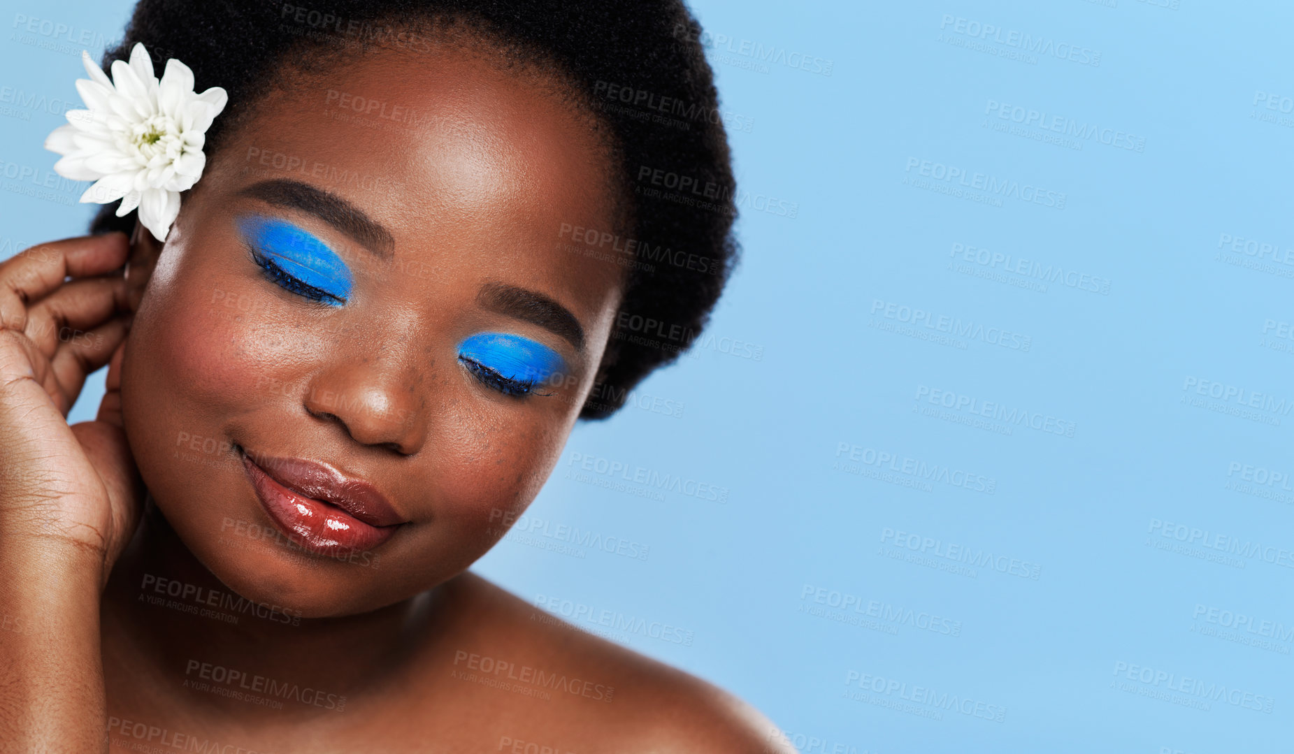 Buy stock photo Makeup, black woman and smile in studio, flower and organic eyeshadow on blue background. Cosmetic, confidence and eyeliner for glamour and female person, face and skincare for glow and treatment