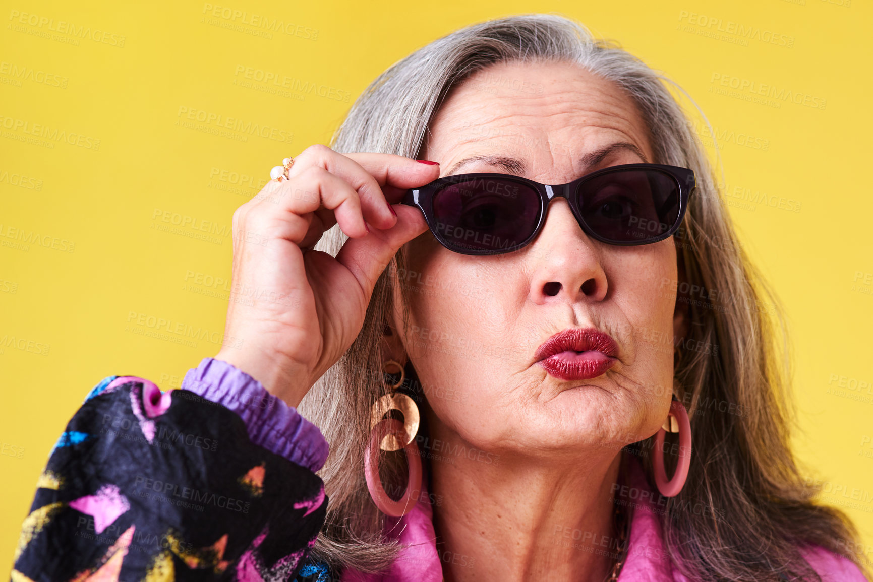 Buy stock photo Sunglasses, fashion and cool senior woman in studio with kiss, confidence and wellness in retirement. Relax, face and trendy elderly person with fun style, designer eyewear and yellow background.