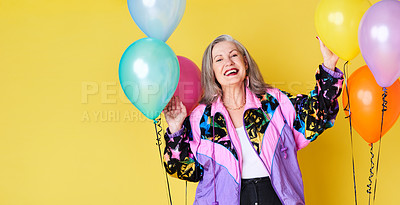 Buy stock photo Portrait of a cheerful and stylish senior woman posing with balloons against a yellow background
